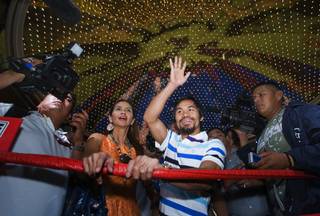 Filipino boxer Manny Pacquiao, center, waves to fans during fighter arrivals in the lobby of the MGM Grand Tuesday, May 3, 2011. Pacquiao will defend a WBO welterweight title against Shane Mosley of Pomona, Calif. at the MGM Grand Garden Arena on Saturday.