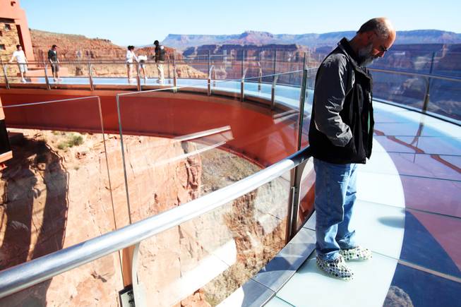 Ian Bailey of Pitt Meadows, of British Colombia, walks the Skywalk at Grand Canyon West Tuesday, May 3, 2011, after the glass panels were replaced.