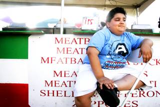 Sonny Marks, 8, the owner of Fat Sonny's, sits in front of his Italian food booth during the San Gennaro Feast outside of the Silverton in Las Vegas on Thursday, May 5, 2011.