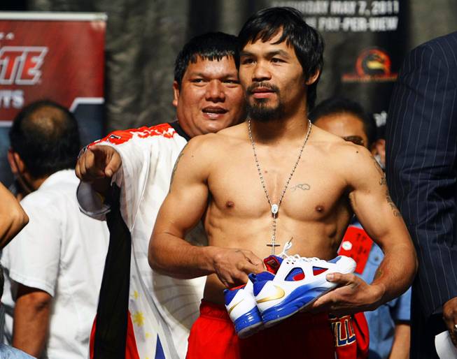 Filipino trainer Buboy Fernandez (L) points out a member of the audience to Manny Pacquiao of the Philippines during weigh-in at the MGM Grand Garden Arena Friday, May 6, 2011. Pacquiao will defend his WBO welterweight title against Mosley at the arena Saturday.