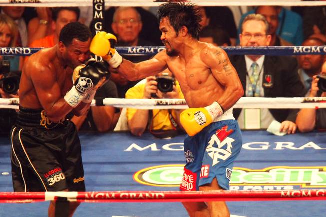 Shane Mosley takes a punch from Manny Pacquiao during their WBO welterweight title fight at the MGM Grand Garden Arena on May 7, 2011.