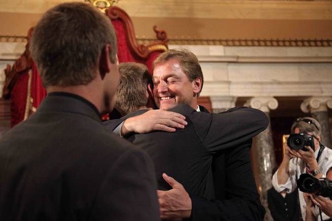 Sen. Dean Heller hugs his oldest son, Harris, 22, in the Old Senate Chamber as his other son, Drew, 21, looks on, following his official swearing as Nevada's 25th senator on the Senate floor May 9, 2011. 