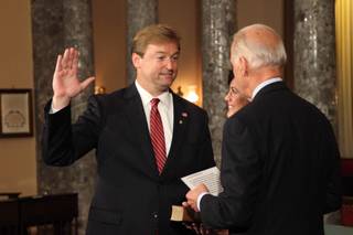 Sen. Dean Heller re-enacts taking the official Senate oath of office from Vice President Joe Biden in the Old Senate Chamber, with his wife Lynne holding a Bible, in the Capitol on May 9, 2011. 