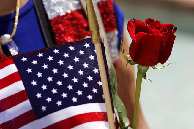 Anita Gargus holds a rose and an American flag before participating in a Special Forces Ceremony at the Southern Nevada Veterans Memorial Cemetery in Boulder City Sunday, May 29, 2011.