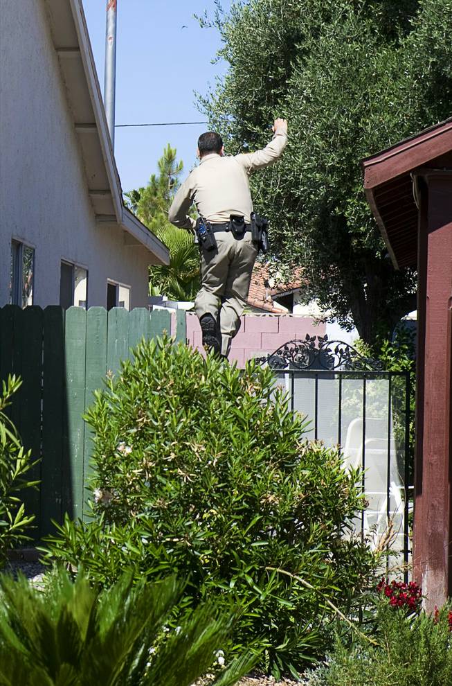 Metro Police Officer Roberto Henderson, a patrol officer in Northwest Area Command's Burglary Reduction Program, balances on a block wall as he chases after a suspect in a neighborhood near Vegas and Buffalo drives Thursday, June 13, 2011. The suspect, who ran from officers when questioned, had outstanding warrants and burglary priors, Henderson said.