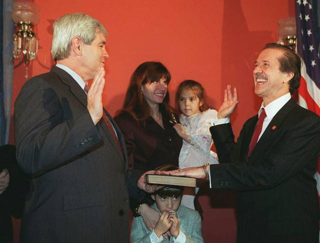 Rep. Sonny Bono, R-Calif., right, re-enacts his oath of office from House Speaker Newt Gingrich on Jan. 4, 1995, on Capitol Hill. Bono's wife Mary holds the Bible and their daughter Chianna as Bono's son Chesare huddles underneath. 