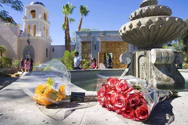 Flowers are left by a fountain outside a home where entertainer Michael Jackson used to live on Palomino Lane Saturday, June 25, 2011. The homeowner opened a portion of the home to the public to mark the second anniversary of the entertainer's death.