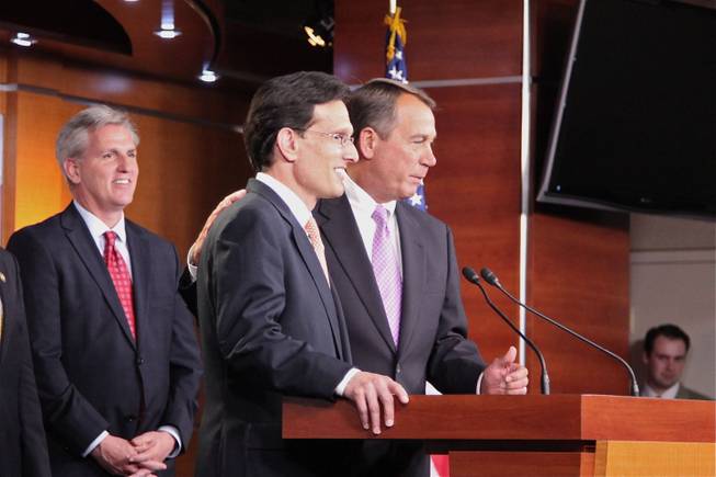 House Speaker John Boehner puts his arm around House Majority Leader Eric Cantor as he tells reporters he and Cantor are a team, in a press conference Thursday afternoon at the U.S. Capitol.