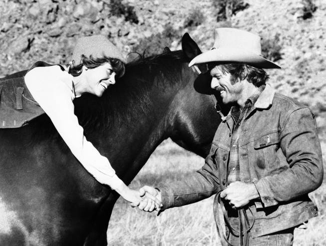 In this photo provided by Columbia Pictures, ex-rodeo star Robert Redford gives TV newscaster Jane Fonda her first riding lesson, aboard a stolen million-dollar stallion in the Columbia Pictures release, "The Electric Horseman," December 1979.