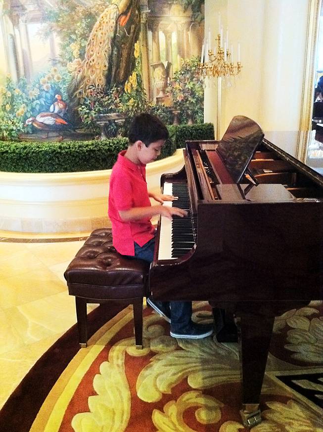 Ethan Bortnick, a 10-year-old piano prodigy, will perform this weekend at the Hilton, making him the youngest entertainer to headline a show in Las Vegas. In this photo, he plays piano in a VIP suite at the Hilton.