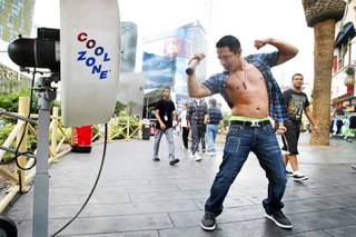 Evan Kennedy, 21, of El Paso, cools down in front of a misting fan on the Las Vegas Strip Sunday, July 24, 2011.