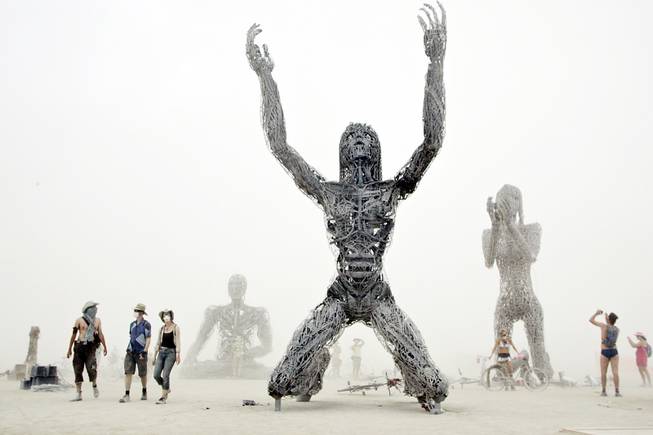 In the midst of a white-out dust storm, Burners visit "Crude Awakening", a multi-artist structure at Burning Man in 2007. 