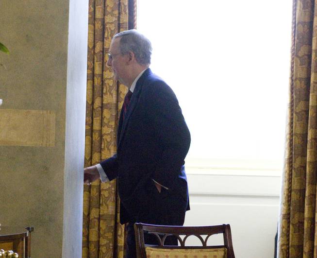 Senate Minority Leader Mitch McConnell enters his office on Capitol Hill in Washington, on Sunday, July 31, 2011.