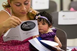 Diana Munoz and her daughter Naomi Nicole May, 4 months, look over a program before a Nurse-Family Partnership Graduation at the Southern Nevada Health District Tuesday, August 9, 2011.