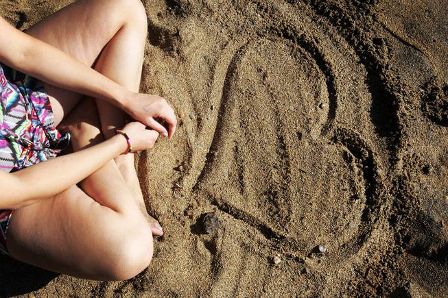 Angela Meidaa of Los Angeles admires a heart she drew on the beach  near Zephyr Cove on the Nevada side of Lake Tahoe Wednesday, August 10, 2011.