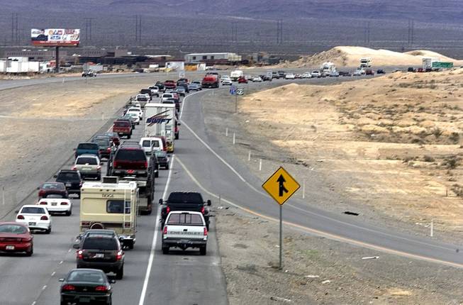A pair of trucks pass illegally on the right shoulder as race fans jam Interstate 15 near Lamb Boulevard as they head to the CarsDirect.com NASCAR race at the Las Vegas Motor Speedway Sunday, March 5, 2000. This photo was taken at 10:45 a.m., just 45 minutes from the scheduled start time.