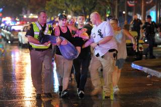 Family members tend to their injured relatives as IFD and paramedics tend to the victims of a stage collapse before concert at Indiana State Fair Grandstands Saturday night.