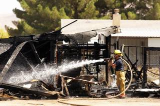 Clark County firefighters clean up a shed fire that occurred behind a home at 2124 Walnut Road between East Lake Mead Boulevard and East Carey Avenue on Wednesday, Aug. 17, 2011.
