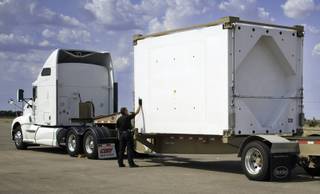 This undated image provided by the Waste Isolation Pilot Plant shows a New Mexico Department of Public Safety Motor Transportation Police Division officer inspecting the TRUPACT-III as it enters the state. The U.S. Department of Energy says this new shipping container used for moving radioactive tools and clothing known as transuranic waste arrived safely in New Mexico this week from South Carolina.