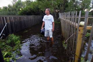 Steve Downing surveys the damage around his house from Hurricane Irene in Nags Head, N.C., Sunday, Aug. 28, 2011. The hurricane unloaded more than a foot of water on North Carolina, spun off tornadoes in Virginia, Maryland and Delaware, and left 3 million homes and businesses without power as it moved up the East Coast. (AP Photo/Gerry Broome)