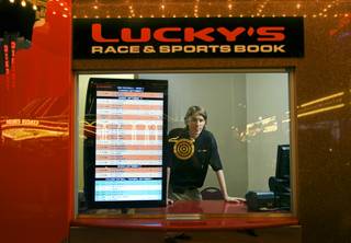 Ticket writer Russ Gilgan poses at the new Lucky's sports book outdoor, walk-up betting window in the Riviera Thursday, September 1, 2011. The display at left shows betting lines for NFL and college football.