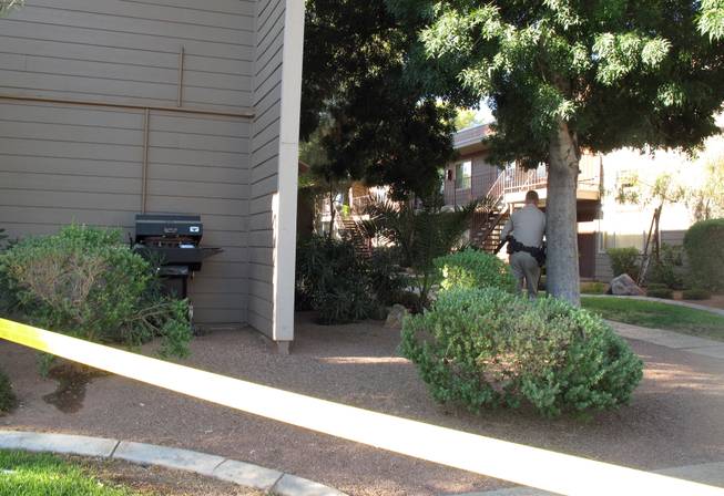 An officer waits near the scene of a homicide Thursday morning at the Canyon Pointe apartments on Harmon Avenue in the eastern valley.