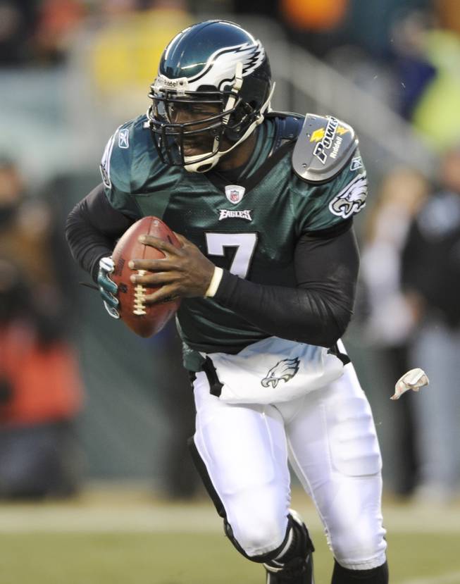 In this Jan. 9, 2011, photo, Philadelphia Eagles quarterback Michael Vick (7) runs from a tackler during the first half of an NFL wild card playoff football game against the Green Bay Packers in Philadelphia. 