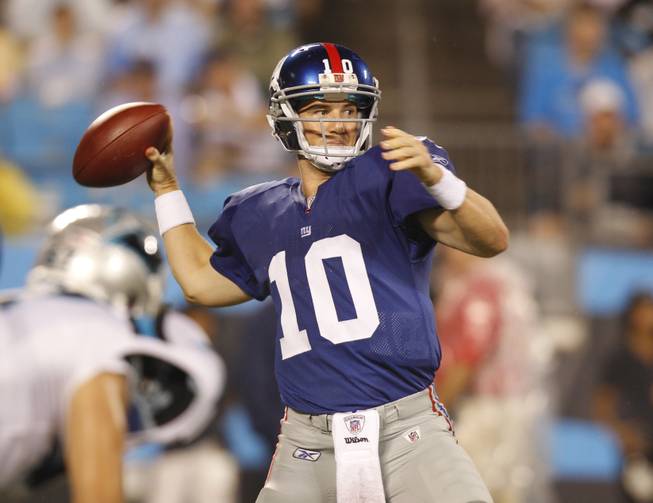 New York Giants' Eli Manning (10) prepares to throw a pass against the Carolina Panthers in the first quarter of an NFL football game in Charlotte, N.C., Saturday, Aug. 13, 2011.
