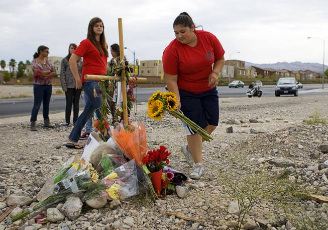 Sarah Wescott, right, an Arbor View High School band member, places flowers at a memorial for 15-year-old Alyssa Otremba near Grand Teton Drive and Tee Pee Lane Monday, September 5, 2011. 
