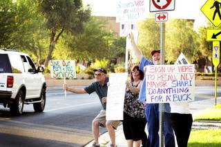 Residents hold up signs to motorists passing on Civic Center Drive urging the recall of North Las Vegas Mayor Shari Buck as they protest in front of the North Las Vegas City Hall on Wednesday, Sept. 7, 2011.