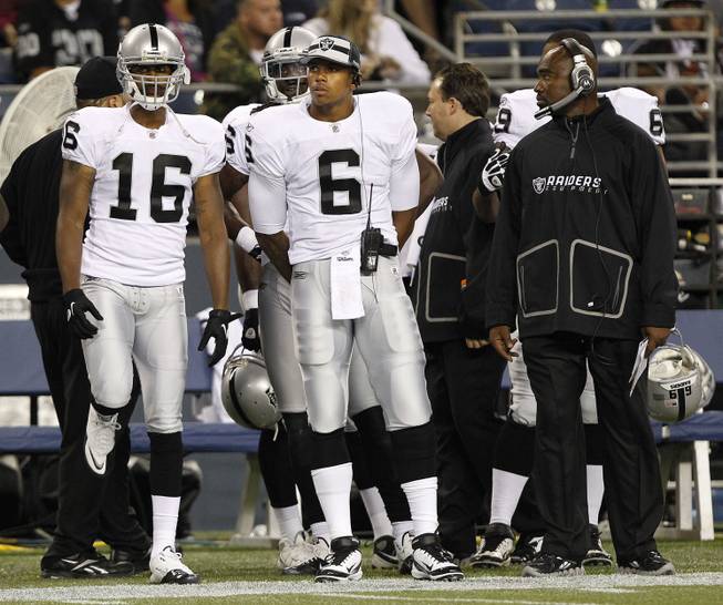 Raiders players, including rookie quarterback Terrelle Pryor, watch a preseason game from the sidelines.
