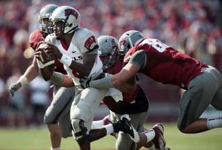 Washington State defensive end Travis Long, right, and defensive tackle Kalafitoni Pole, center, sack UNLV quarterback Caleb Herring (8) as linebacker Alex Hoffman-Ellis, left, pursues during the first half of their NCAA college football game on Saturday, Sept. 10, 2011, in Pullman, Wash.