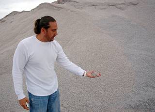 Tommy Fisher, of Fisher Sand & Gravel, holds a handful of gravel at the Sloan Quarry Wednesday, September 14, 2011.  Fisher mixes crumb rubber from old tires with oil and rock to make the rubberized asphalt that is being used in the repaving of Interstate 15.