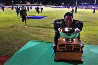 Green Valley running back Aaron Love grabs the Henderson Bowl trophy after their annual game against Basic Friday, September 16, 2011. After three consecutive losses to Basic, Green Valley won the game 36-33.