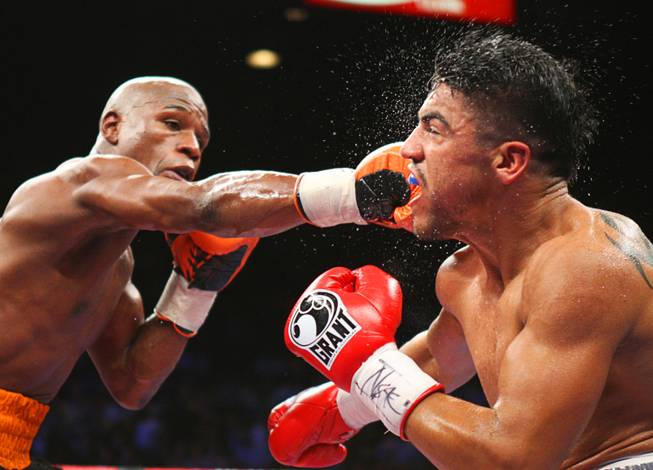 Floyd Mayweather Jr., left, battles it out with WBC welterweight champion Victor Ortiz during their title fight at the MGM Grand Garden Arena Saturday, September 17, 2011.