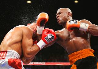 WBC welterweight champion Victor Ortiz, left, takes a punch from Floyd Mayweather Jr. during their title fight at the MGM Grand Garden Arena on Saturday, Sept. 17, 2011.