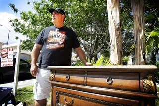 Tony Mateus with a marble top Bombay table at his yard sale in Henderson on Saturday, Sept. 24, 2011.