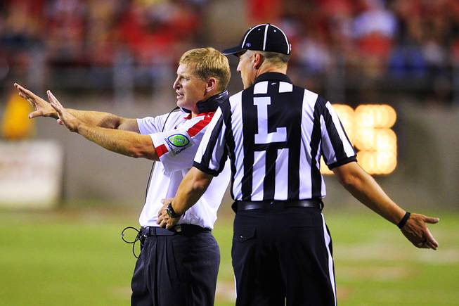 UNLV coach Bobby Hauck questions a call with line judge Marc Bovos during their game against Southern Utah University Saturday, September 24, 2011.
