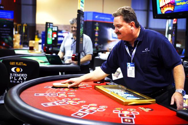 Willis Parsons of Galaxy Gaming Inc. cleans off a table during setup for the Global Gaming Expo at the Sands Convention Center on Monday, Oct. 3, 2011.