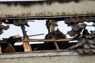 A firefighter looks over a hole in a mansard roof after lightning struck an office building at 2785 E. Desert Inn Road on Monday, Oct. 3, 2011. City of Las Vegas and Clark County fire units responded to the fire. 