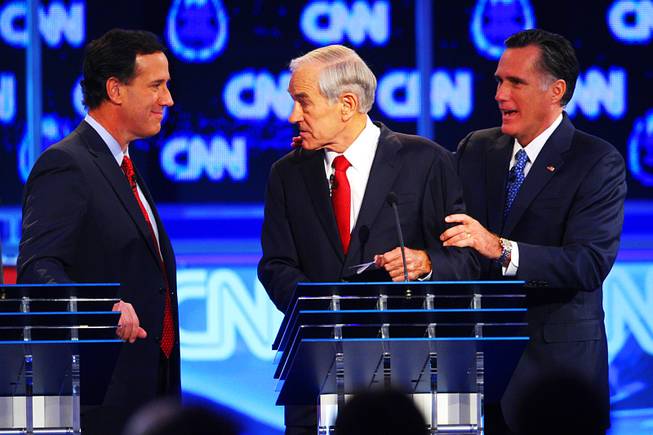 Rick Santorum, Ron Paul and Mitt Romney interact during a break in the GOP presidential debate sponsored by CNN on Tuesday, Oct. 18, 2011, at the Venetian.