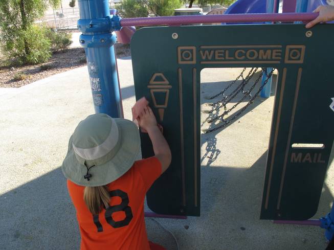 A young volunteer works to remove graffetti, gum and other marks off the playground in Sandstone Ridge Park in North Las Vegas for Make a Difference Day.