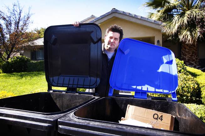 Todd Korgan stands with his new recycling and garbage bins at his home near downtown Las Vegas on Wednesday, Oct. 26, 2011.