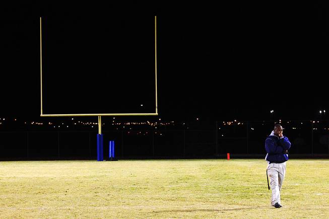 Canyon Springs coach Hunkie Cooper takes a moment to collect himself after talking to his players in the wake of their 22-21 overtime win over favored Las Vegas Thursday, Oct. 27, 2011.
