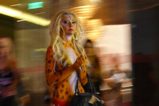 A woman dressed as a tiger clutching a purse was among the costumed creatures cavorting Saturday night outside the Chandelier Bar on the Las Vegas Strip.