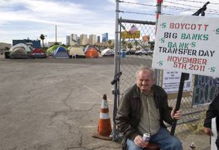 Henri Palnar holds a sign on Swenson Street in front of the Occupy Las Vegas site near Tropicana Avenue Thursday, Nov. 3, 2011.