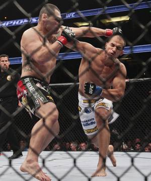 Junior dos Santos, right, of Brazil, fights Cain Velasquez in the UFC mixed martial arts heavyweight title bout Saturday, Nov. 12, 2011, in Anaheim, Calif. Dos Santos won by knockout in the first round. 