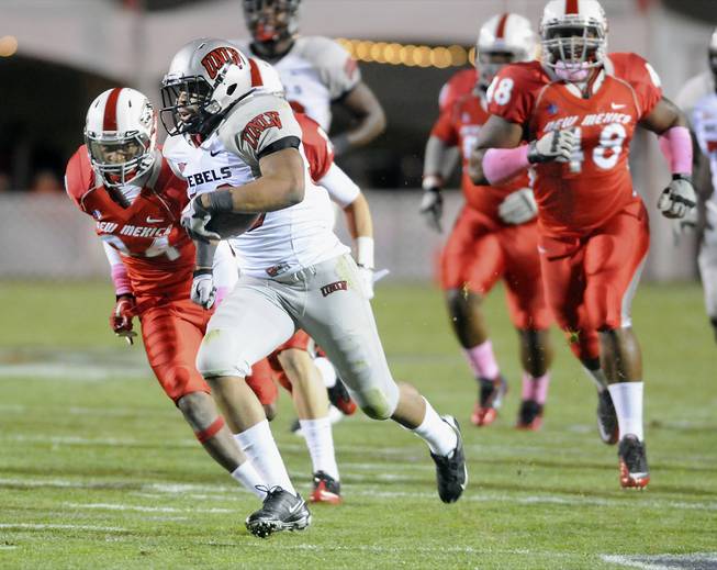 UNLV's Dionza Bradford (33) heads into the end zone followed by New Mexico defenders in the first half of their game Saturday, Nov. 12, in Albuquerque.