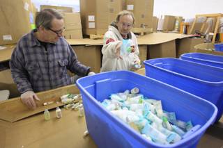 Mike Brennan, left, and James Benson sort hotel shampoo, lotion and conditioner bottles at Clean the World Wednesday, Nov. 16, 2011.