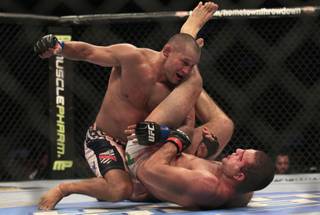 Dan Henderson, top, punches Mauricio Rua during the fourth round of a UFC 139 Mixed Martial Arts light heavyweight bout in San Jose, Calif., Saturday, Nov. 19, 2011. Henderson won by unanimous decision. 